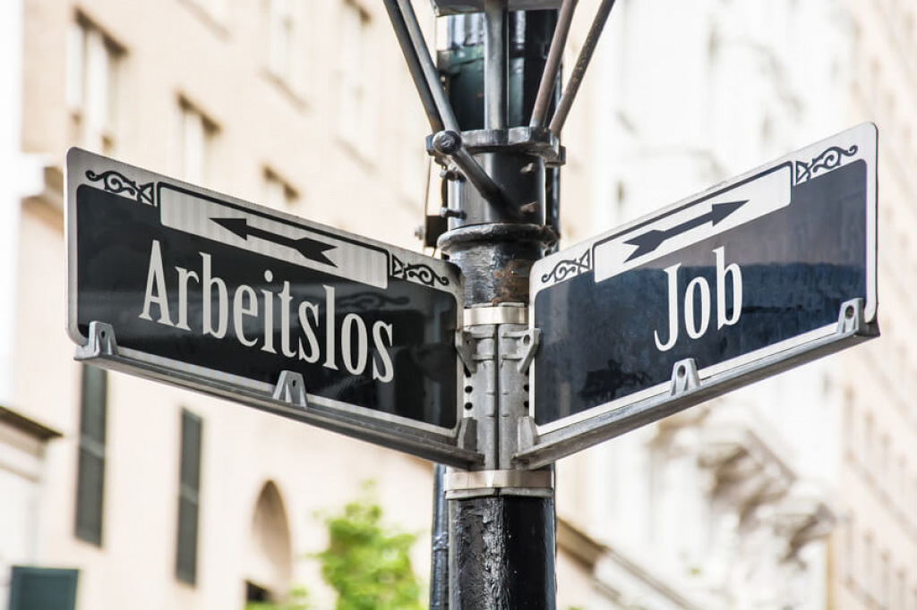 Stra&szlig;enschilder mit den Pfeilen Arbeitslos in die eine und Job in die andere Richtung.